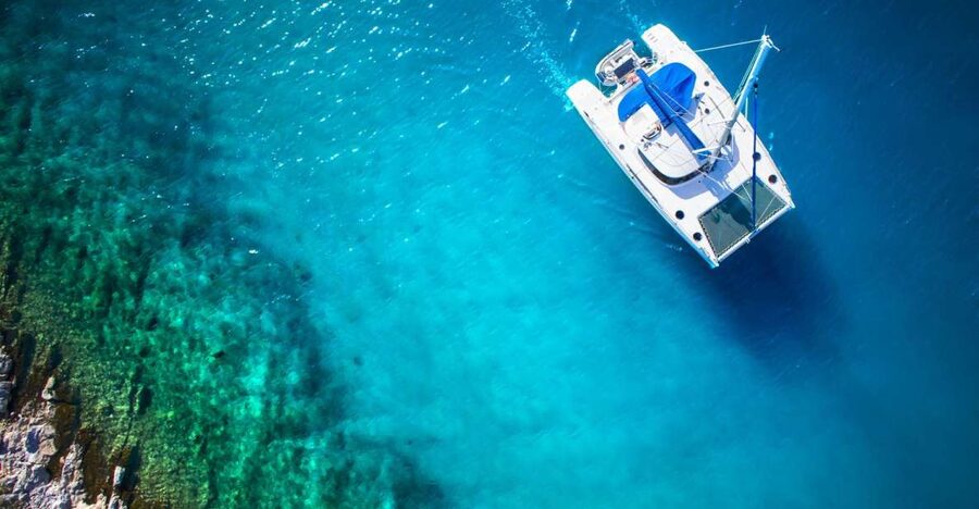From Ornos: Mykonos Delos Catamaran Cruise with Meal & SUP - Rhenia Island and the clear-water stop