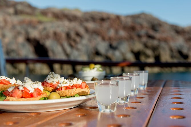 Santorini Caldera Sunset Traditional Cruise with Meal and Drinks - White Beach Is Seen Best From the Water