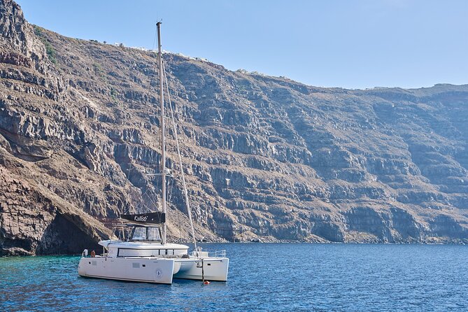 Santorini: Luxury Catamaran Cruise with Fresh Fish BBQ & Drinks - Red Beach and the changing colors of Santorini