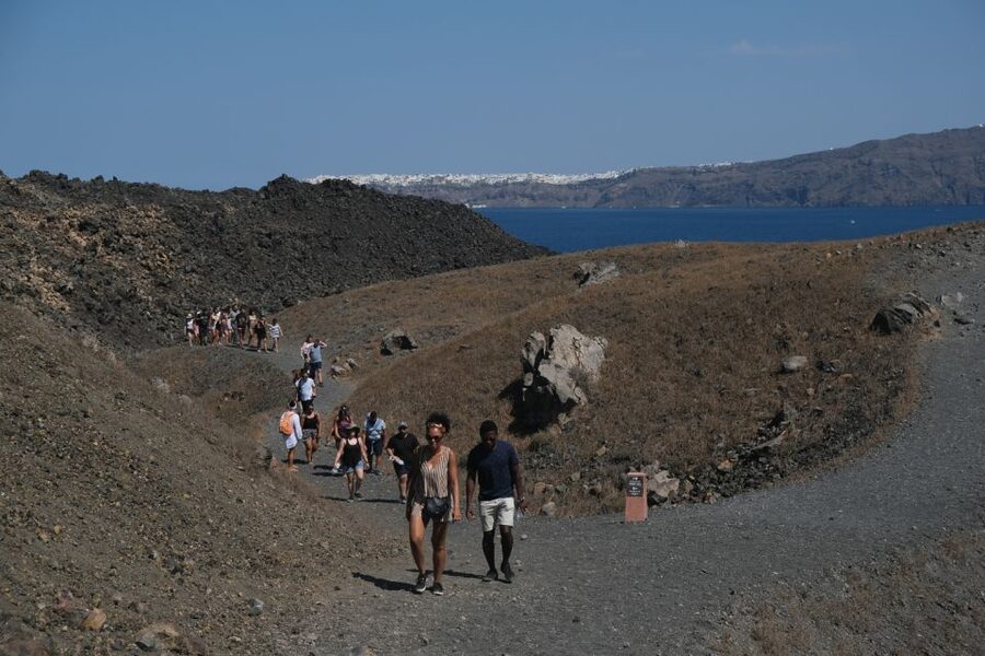 Santorini: Volcano and Hot Springs Sunset Dinner Cruise - Climbing the volcanic cone at Nea Kameni